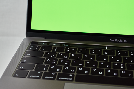 MacBook Air M4 opengeklapt op bureau met grafieken en nieuwswebsites op het scherm