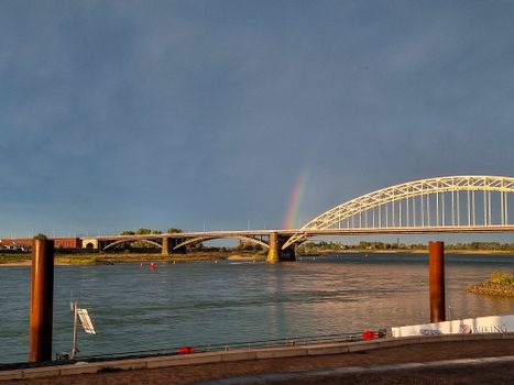 Straatbeeld in centrum Nijmegen met wolkenlucht en mensen op terras tijdens weer in Nijmegen vandaag