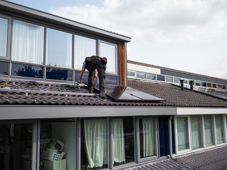 Huiseigenaar bekijkt zonnepanelen en thuisbatterij in woning terwijl energiekosten worden vergeleken