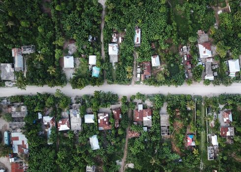 Straatbeeld in Haiti met beschadigde gebouwen, weinig verkeer en zichtbare sporen van de humanitaire crisis